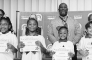 Winnfield Primary School – First Grade From left: Gabrielle Breaux, Sadie Garrett, Dixxie Hernandez and Ellie Stroud.. Assistant Principal Resa Johnson, Kiwanian Mary Lou Blackley, Principal Byron King and Kiwanian Ethel Howell.