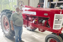 Club member Joel Bryant stands by his “friendly restored” 1957 Farmall 450.