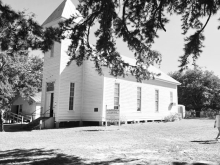 Framed by the boughs of a native Winn Parish shortleaf pine, the historic St. Maurice Methodist Church (built in 1874 by John E. Jones) stands in bright autumn sunlight during the annual cemetery homecoming on Sunday, October 11, 2026.
